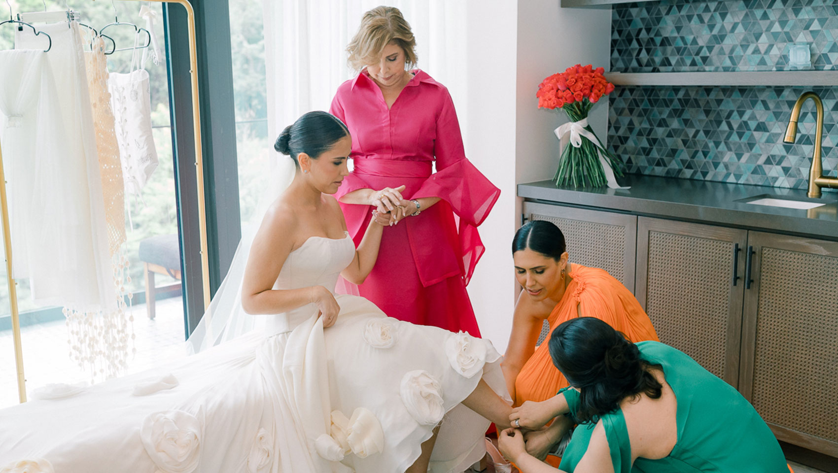 Bridesmaids help put on bride's shoe at Kimpton Grand Roatan