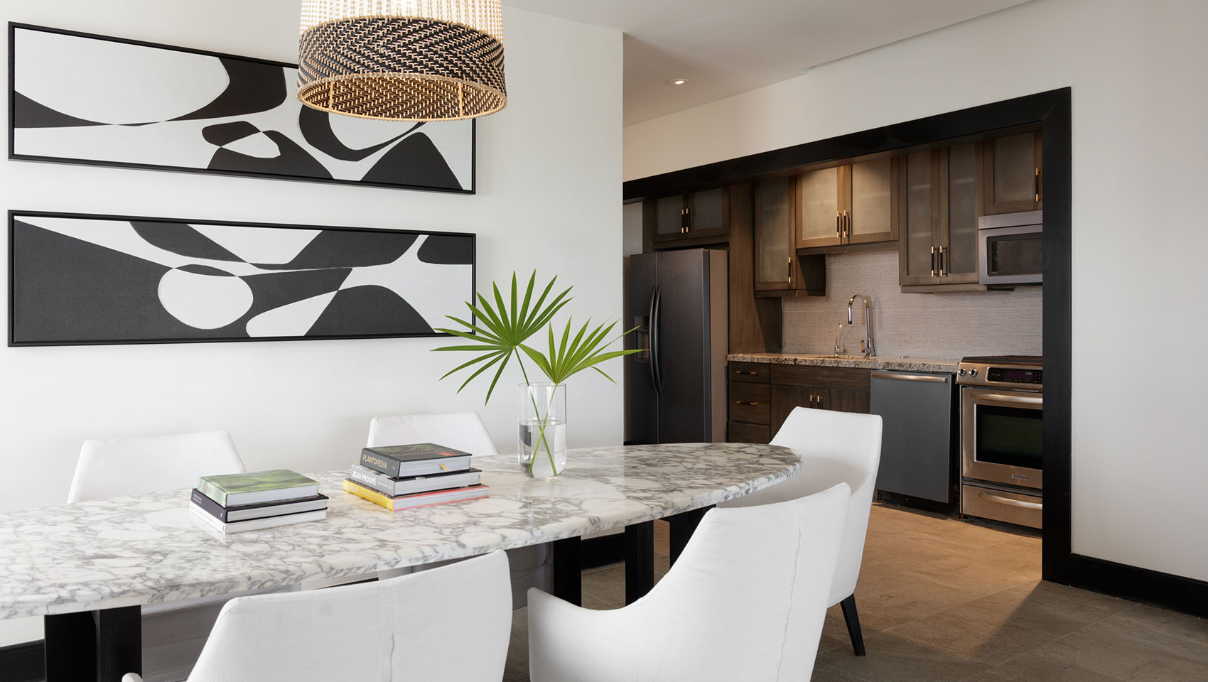 Dining table with view of kitchen in One Bedroom Premium Villa Suite Beachfront at Kimpton Grand Roatan Resort