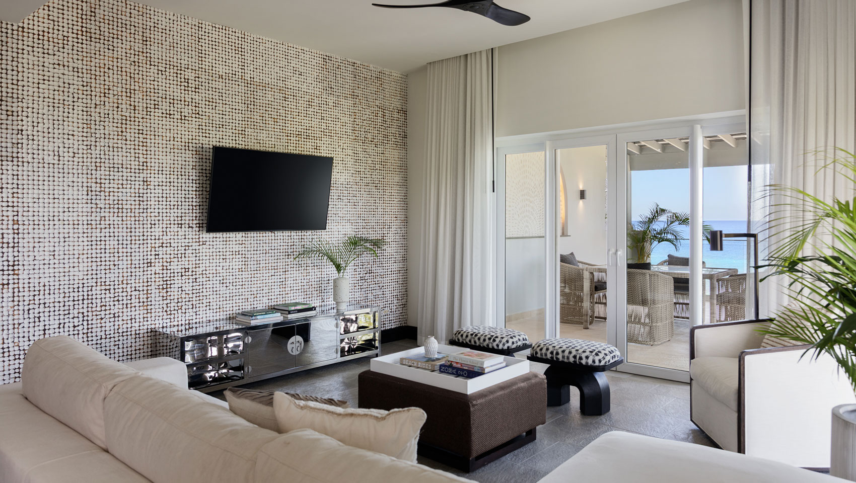 Living room seating and TV in One Bedroom Premium Villa Suite Beachfront at Kimpton Grand Roatan Resort
