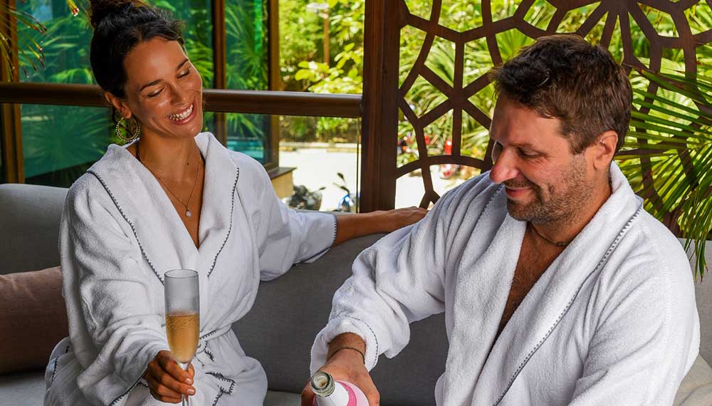 Couple in spa robes drinking sparkling wine at Kimpton Grand Roatan Kao Kamasa Spa
