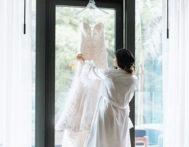 woman admiring hanging wedding dress
