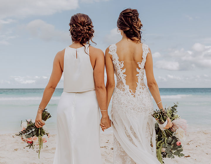 brides walking and holding hands on the beach
