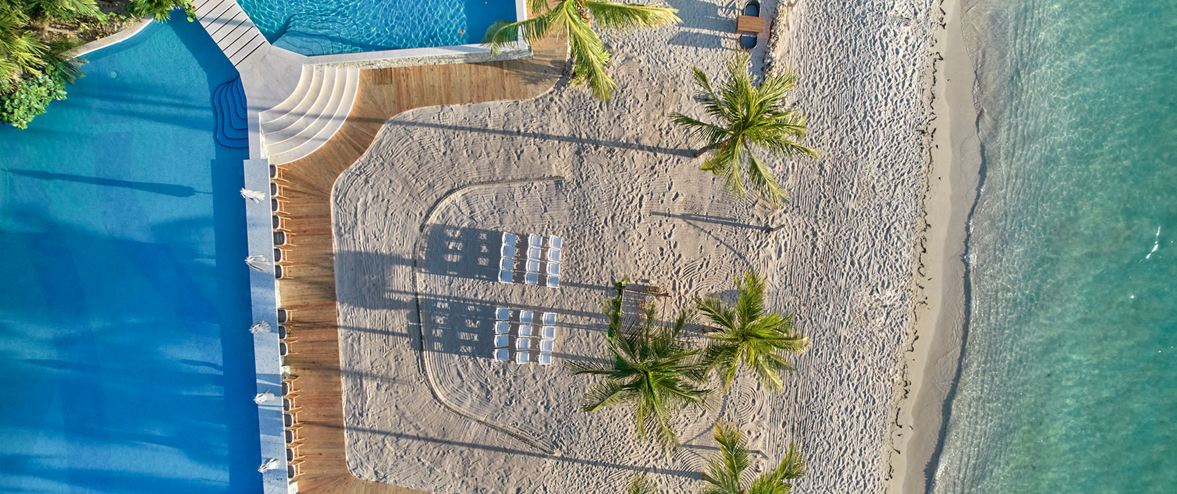 Overhead drone shot of Roatan beach with wedding chairs set-up