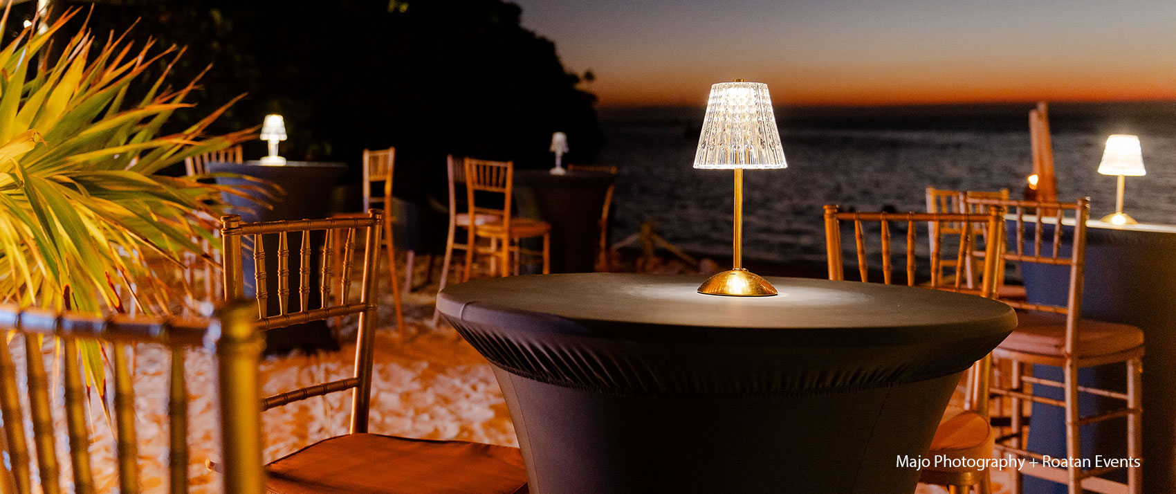 table with lamp and evening view of ocean
